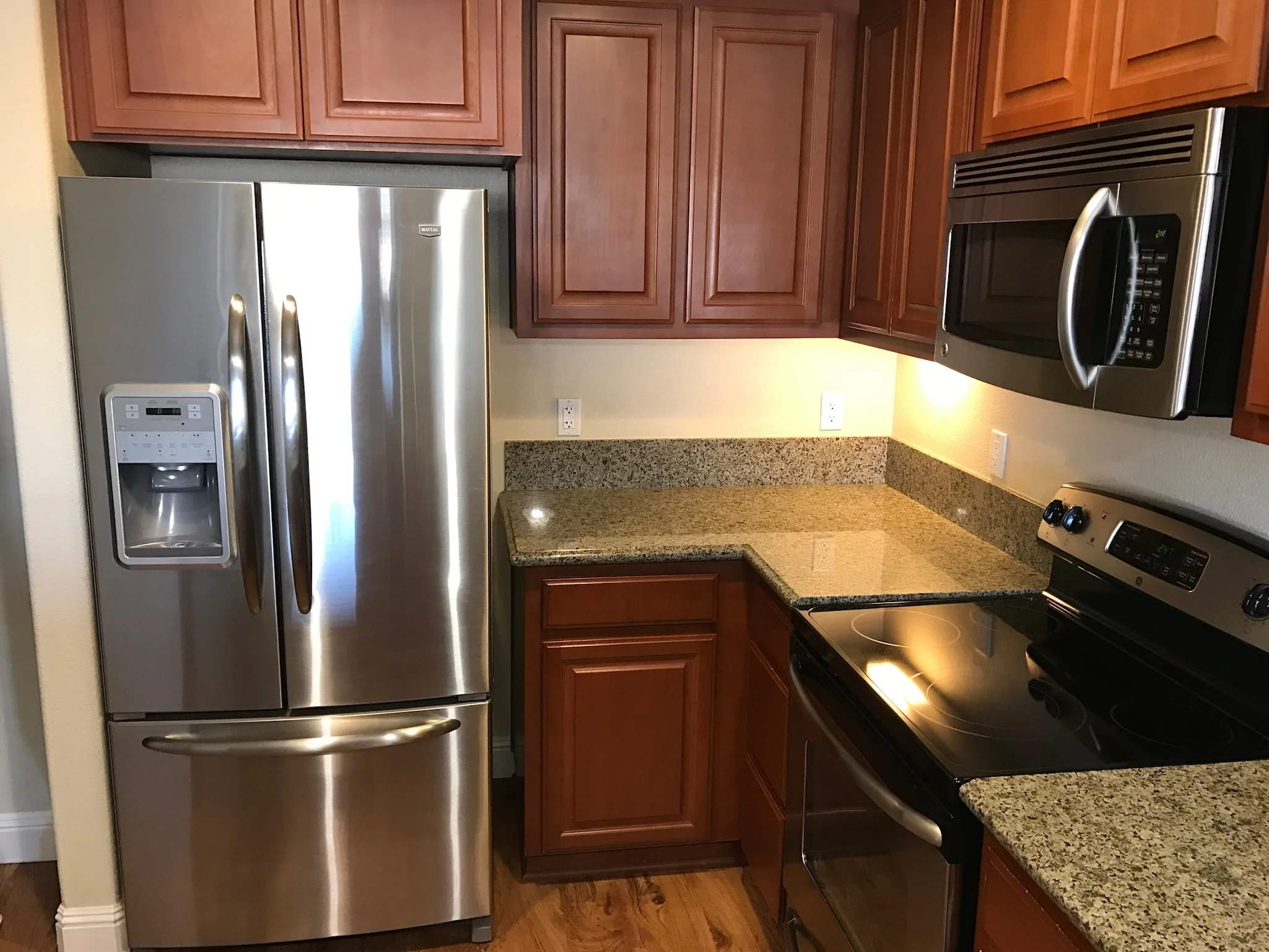 Kitchen with stainless steel appliances and granite counters in downtown Gilroy apartment